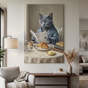 Può includere: Una stampa d'arte da parete che raffigura un gatto grigio che indossa una vestaglia blu, seduto a un tavolo mentre legge un giornale intitolato The Feline Times con il titolo Catnip Futures Soar. Un cornetto, caffè e burro sono sul tavolo.