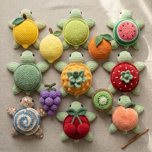 May include: A collection of handmade crochet turtle toys, each designed to resemble a different fruit. The turtles feature various colors, including yellow lemons, green limes, orange oranges, and red strawberries. The toys are arranged on a neutral surface.
