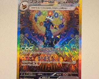 Può includere: Una carta collezionabile Pokémon Umbreon ex olografica raffigurante una creatura blu scuro con anelli gialli, una corona di cristallo e uno sfondo vibrante e intricato di motivi geometrici colorati, con 280 HP e testo in giapponese.