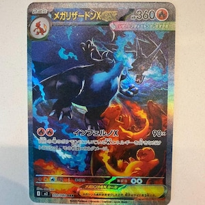 May include: A Japanese Mega Charizard X trading card featuring a holographic illustration of a large dark blue dragon-like creature with blue flames, alongside smaller orange dragon figures. The card displays 360 HP, text in Japanese, and the number 110/080 SAR.