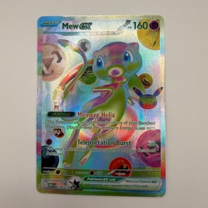 Puede incluir: Una carta coleccionable Mew ex holográfica con acabado de lámina arcoíris. La carta muestra al personaje Mew, 160 HP, la habilidad Memory Helix y el ataque Teleportation Burst. Incluye varios iconos circulares coloridos y texto.