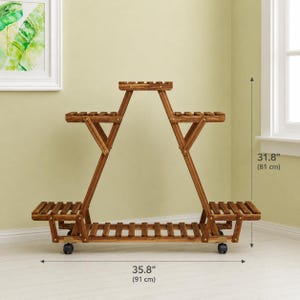 May include: A brown wooden plant stand with a tiered, triangular frame featuring multiple slatted shelves for displaying plants. The stand is equipped with wheels at the base and measures 35.8 inches in width and 31.8 inches in total height.
