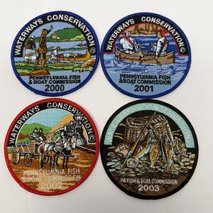 May include: Four circular embroidered patches from the Pennsylvania Fish & Boat Commission, dated 2000, 2001, 2002, and 2003. Each patch features the text Waterways Conservation and depicts outdoor scenes including canoeing, horse-drawn wagons, and fishing.