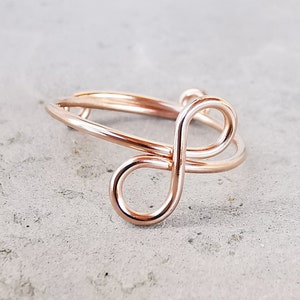 Op de afbeelding: Een ring met een oneindigheidssymbool van roségoud, gemaakt van draad.