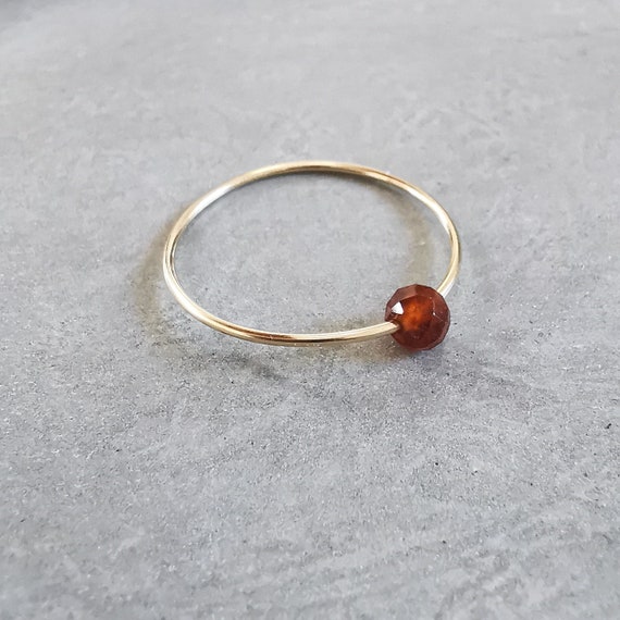 Gold ring with garnet, a noble piece of jewelry that impresses with its delicate elegance and the sparkling garnet stone