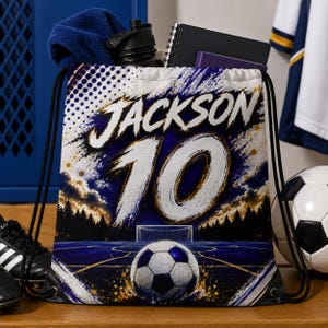 May include: A drawstring backpack featuring a soccer-themed graphic with the name JACKSON and the number 10 in large white text. The design includes a soccer ball on a blue field, a goal, and a forest silhouette against a dark, starry sky.