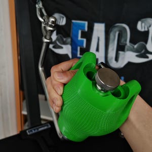 May include: A bright green textured grip handle for exercise equipment featuring a metallic silver screw-top cap. The handle is attached to a stainless steel cable attachment mechanism with a carabiner and a bolt, designed for strength training.