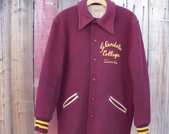 May include: A maroon varsity jacket with gold lettering that reads "Glendale College Tennis". The jacket has gold stripes on the sleeves and pockets.