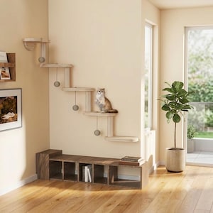 May include: A wall-mounted cat climbing system featuring five light-colored wooden platforms arranged in a stepped pattern, with four hanging grey ball toys attached to the underside of the shelves and a cat sitting on the second lowest platform.