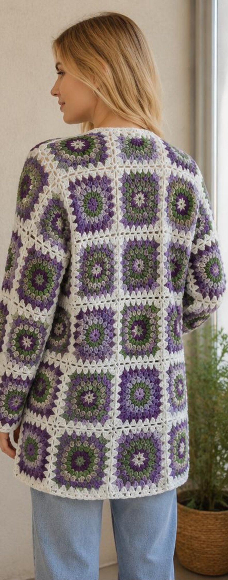 May include: A long-sleeved cardigan constructed from joined square crochet motifs. The pattern features a repeating design of concentric circles in shades of purple, light green, and dark green, all outlined with a white yarn border.