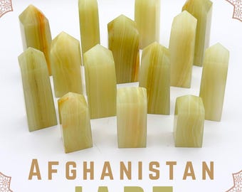 May include: A collection of pale green and yellow banded stone towers with pointed tops, arranged in a group. The text AFGHANISTAN JADE is printed in large tan letters at the bottom, with a palm tree icon centred at the top of the image.
