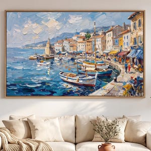 May include: An oil painting in a wooden frame depicting a coastal harbor scene with multiple small boats docked along a stone quay. The composition features textured brushstrokes of blue water, colorful buildings, and a bright sky with clouds.