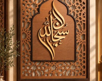 May include: A rectangular wooden wall art piece featuring intricate laser-cut geometric patterns surrounding a central arched panel. The center displays raised, gold-toned Arabic calligraphy script set against a smooth, medium-brown wood background.