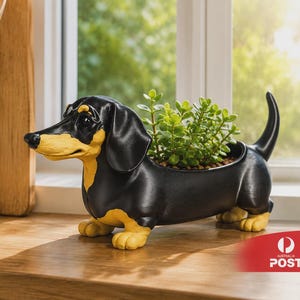 May include: A black and yellow dachshund-shaped planter filled with green plants. The dog planter is made of eco-friendly PLA material and is perfect for small plants. The planter is a great gift idea.