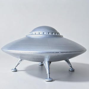 May include: A silver-colored, disc-shaped unidentified flying object model featuring a smooth, rounded dome top with a series of small rectangular windows around the base of the dome and three sturdy, tapered landing legs with flat circular feet.