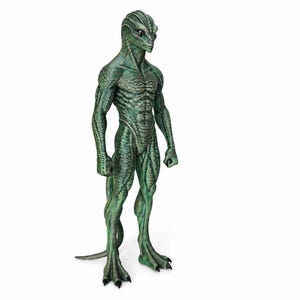 May include: A standing humanoid figurine with green, textured, reptilian skin. The creature features a slender, muscular build, a pointed head with large dark eyes, and a long tail extending from the back. It has three-toed feet with dark claws.