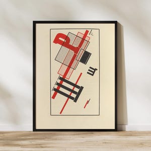 May include: A framed wall art print featuring a geometric composition on a cream background. The design includes bold red and black lines, rectangular shapes, a grid pattern, and a stylized letter P, all enclosed within a thin black rectangular border.