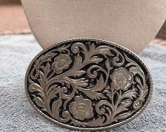 Hebilla de cinturón estilo western con diseño floral en tono plateado. Hebilla decorativa vaquera.