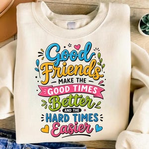 Peut inclure: Un sweat-shirt à col rond couleur crème avec une impression graphique colorée indiquant Good Friends Make The Good Times Better And The Hard Times Easier dans diverses polices, agrémenté de petits cœurs, étoiles et feuilles.
