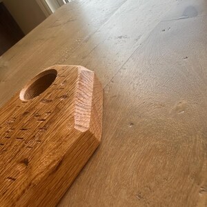 May include: A light brown wooden board with a textured surface and a circular cutout. The board features a beveled edge with visible wood grain patterns and a natural finish, showcasing the raw texture of the wood material in a close-up view.
