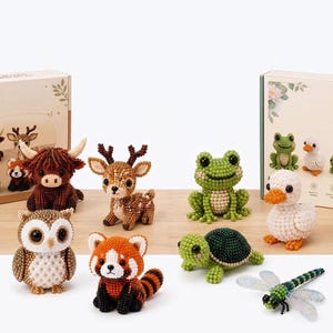 May include: A collection of small animal figurines crafted from tiny beads, including a brown highland cow, a spotted deer, a green frog, a white duck, an owl, a red panda, a green turtle, and a dragonfly with translucent wings.