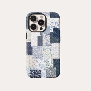 Puede incluir: Una funda para smartphone con un diseño de patchwork de varios patrones florales en azul y blanco. La funda rectangular tiene un recorte para un sistema de cámara de triple lente en la parte superior izquierda, con tonos azul claro y marino.