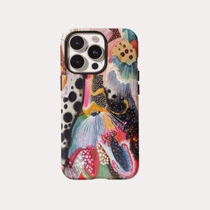 Può includere: Una custodia per smartphone con un design astratto multicolore caratterizzato da elementi neri, bianchi, rosa, arancioni e blu. Il motivo include forme organiche, texture punteggiate e linee sottili che coprono il retro della custodia.