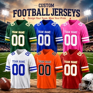 Puede incluir: Seis camisetas de fútbol personalizadas en verde, azul, rosa, blanco, naranja y rojo, cada una con el texto TEAM NAME y el número 00 en el frente. Las camisetas tienen cuello en V y mangas a rayas. Un balón de fútbol y un casco son visibles.