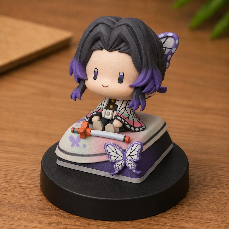 May include: A chibi-style figurine of a character with black hair with purple tips, wearing a patterned kimono. The figure sits on a platform with a butterfly design, and a small sword. The base is black.