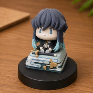 May include: A chibi-style anime figurine featuring a character with dark blue hair that fades to teal at the tips. The figure wears a black uniform and sits on a light blue square base decorated with stylized cloud patterns and a small sword.