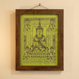 Può includere: Un'opera d'arte da parete incorniciata con uno sfondo verde lime e disegni a linee nere di una figura centrale seduta con corona, circondata da quattro figure più piccole e motivi di bordo intricati con testo in tutto il design.