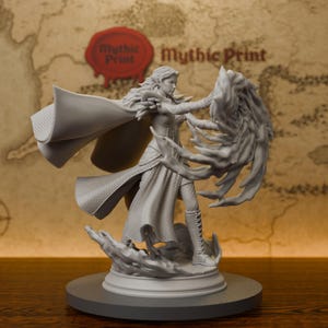 May include: A gray unpainted resin miniature figurine of a fantasy character in a flowing cloak and armor, casting a spell with swirling energy effects from their hands. The figure stands on a circular base with sculpted ground details.
