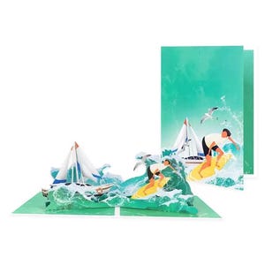 May include: A pop-up greeting card featuring a three-dimensional scene of a sailboat on choppy green ocean waves. The design includes two figures on yellow surfboards riding the waves, with a white sailboat in the background and seagulls.