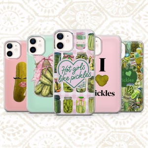 May include: Five clear phone cases featuring pickle-themed designs. One shows a pickle with eyelashes and lips, another a jar with a pink bow, a third with a heart and the text Hot girls like pickles, a fourth with I heart pickles, and a fifth with a collage of pickles.