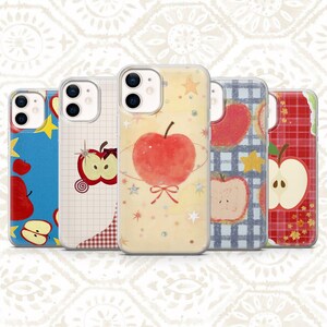 Könnte beinhalten: Fünf Smartphone-Hüllen mit Apfel-Motiven. Die Hüllen zeigen verschiedene Muster, darunter blaue Hintergründe mit gelben Sternen, Gitterlinien mit Apfelscheiben, einen zentralen Apfel mit Schleife, blaues Karomuster mit Äpfeln und rotes Karomuster.