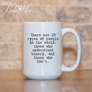 May include: White ceramic coffee mug with a black text design that reads: "There are 10 types of people in the world: those who understand binary, and those who don't."