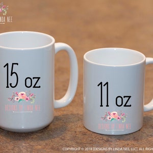 May include: Two white ceramic mugs. The larger mug is labeled "15 oz" and the smaller mug is labeled "11 oz". Both mugs feature a floral design and the text "DESIGNS BY LINDA NEE".