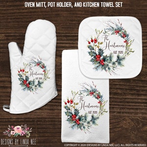 May include: A set of three kitchen items featuring a winter wreath design with holly and berries. The set includes an oven mitt, a pot holder, and a kitchen towel. The text "The Hartmans Est. 2020" is printed on each item.