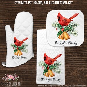 May include: A set of three kitchen items featuring a red cardinal bird perched on a pine branch with holly and bells. The set includes an oven mitt, a pot holder, and a kitchen towel. The text "The Lester Family" is printed on each item.