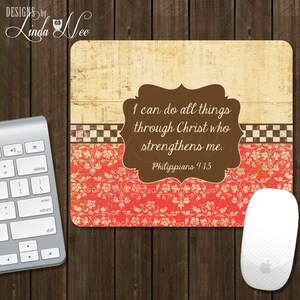 May include: A brown and beige mouse pad with a red floral pattern and a white checkered border. The text "I can do all things through Christ who strengthens me. Philippians 4:13" is printed in a brown frame.
