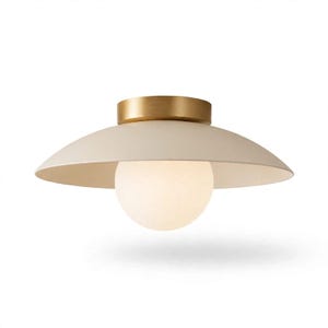 May include: A flush mount ceiling light featuring a wide, matte off-white saucer-shaped shade. The fixture includes a cylindrical brushed brass canopy at the top and a central, spherical frosted glass globe that emits a soft, diffused light.