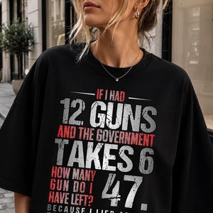 May include: A black t-shirt featuring white and red text that reads: IF I HAD 12 GUNS AND THE GOVERNMENT TAKES 6 HOW MANY GUN DO I HAVE LEFT? 47. BECAUSE I LIED ABOUT HAVING 12. The graphic design uses a distressed font style with bold lettering.