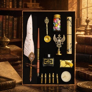 May include: A calligraphy set in a rectangular box containing a white feather quill pen with a gold-tone metal accent, a brown pen holder, a gold-tone melting spoon, a jar of wax beads, a scroll, a wax seal stamp, ink labelled The Feather Pen, a stand, four nibs, and a candle.