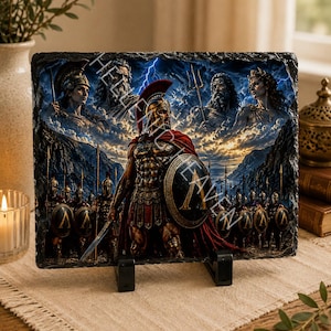 Könnte beinhalten: Eine rechteckige Schieferplatte mit einer lebendigen, detaillierten Illustration eines spartanischen Kriegers in rot-goldener Rüstung vor einer Armee, mit mythologischen Figuren in den Wolken und dem Text HELLENIC HEAVEN auf dem Bild.