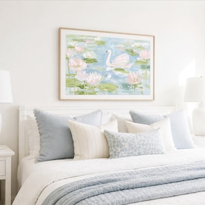 May include: A framed horizontal wall art print featuring a white swan swimming in a pond filled with pink water lilies and green lily pads. The painting uses soft pastel tones of blue, green, and pink to depict a serene aquatic scene.