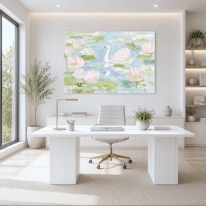 May include: A rectangular wall art print featuring an impressionistic painting of a white swan swimming among pale pink lotus flowers and green lily pads on a light blue water surface, displayed in a bright, modern office space above a desk.