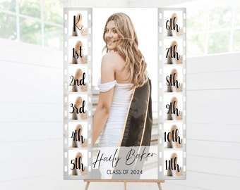 May include: A graduation photo booth backdrop with a film strip design. The backdrop features a photo of a graduate in a white dress and black graduation gown. The film strip design includes numbers from 1st to 11th and the letter K. The text "Hailey Baker" and "Class of 2024" is printed on the backdrop.