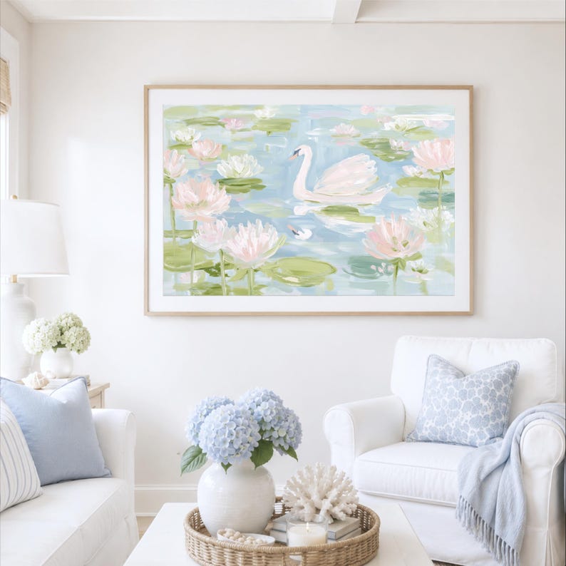 May include: A framed horizontal wall art print featuring an impressionistic painting of a white swan swimming in a pond filled with light pink water lilies and green lily pads, rendered in soft pastel tones of blue, green, and white.