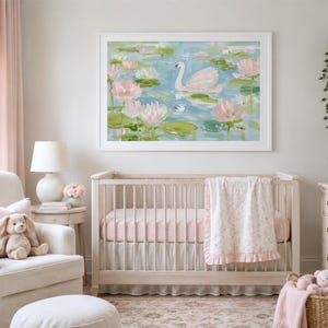May include: A rectangular wall art print featuring an impressionistic painting of a white swan swimming in a blue pond surrounded by pink water lilies and green lily pads, enclosed in a simple white frame and displayed above a wooden baby crib.