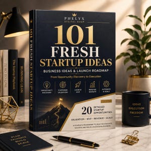 May include: A hardback book titled 101 Fresh Startup Ideas with a dark blue cover and gold text. The cover features a mountain graphic, five icons representing business stages, and the text Business Ideas & Launch Roadmap. A black pen lies nearby.